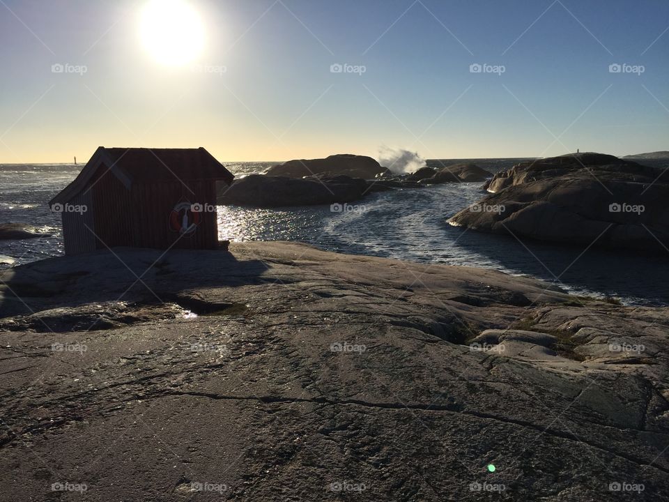 By the sea. Sea, rocks and a small hut