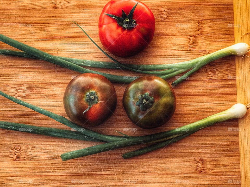 Fresh chocolate tomatoes with scallions 