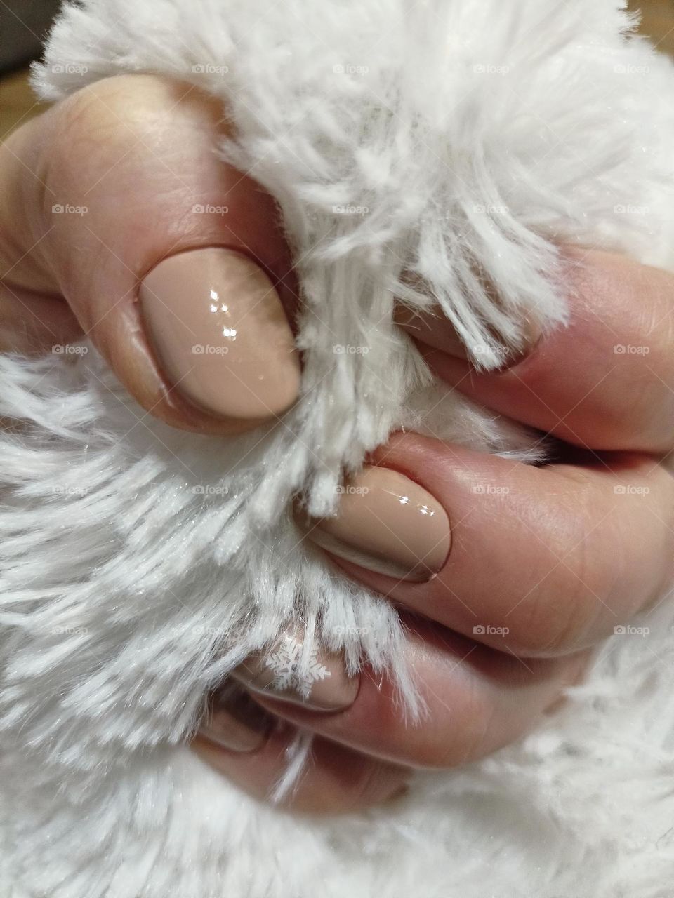 manicure, color coffee with milk, white snowflake on nails, white background, fluffy, female hand, nails, fingers