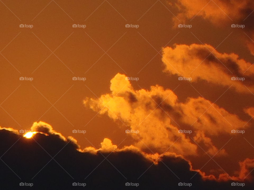 Orange sunrise . Sun just peaking up over cloud in an orange sky