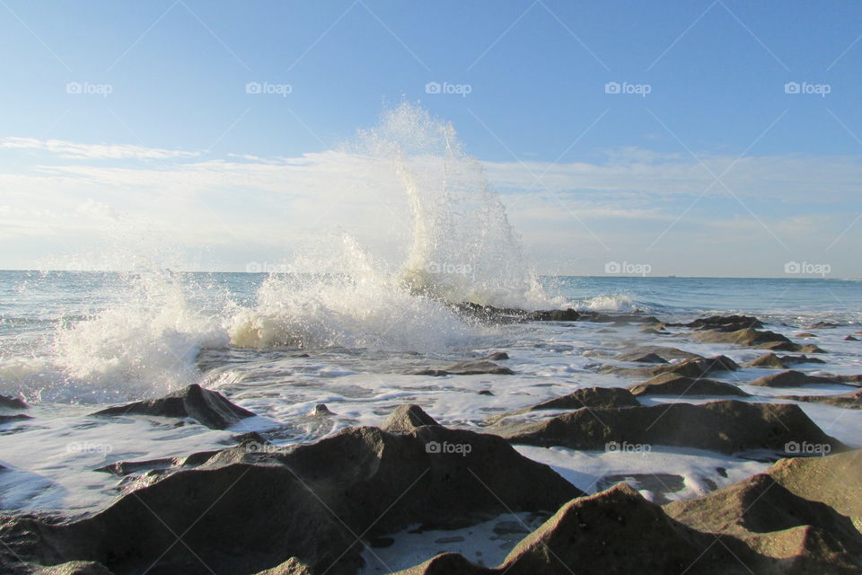 Wave crashing on rock in sea