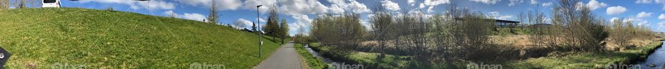 Walk along pedestrian path, following a stream on a sunny day in Kopavogur,Iceland