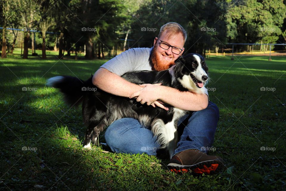 Homem, adulto, loiro, barbudo, com seu cachorro.