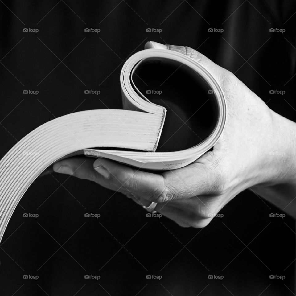 Holding book in hand.Black and white background.