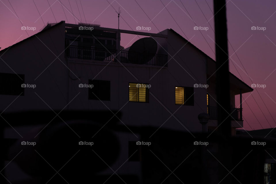 Lights on in the apartment during the evening sky