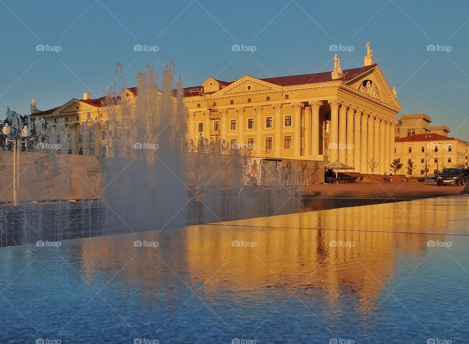 Yellow building with a fountain. 