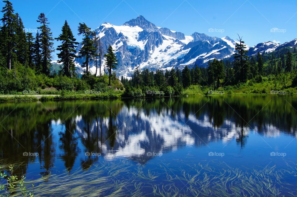 Snowy mountain reflected on mirror lake