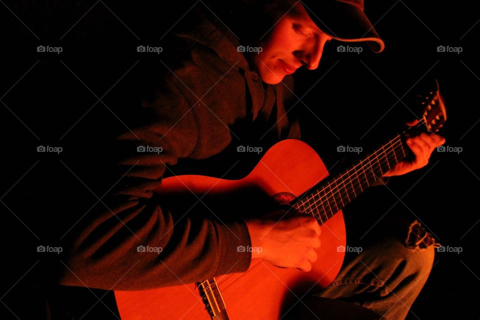 Close-up of a man plying guitar