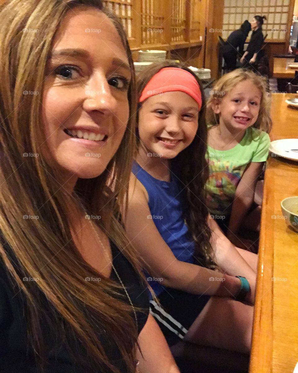 Close-up of a mother sitting in restaurant with her daughters