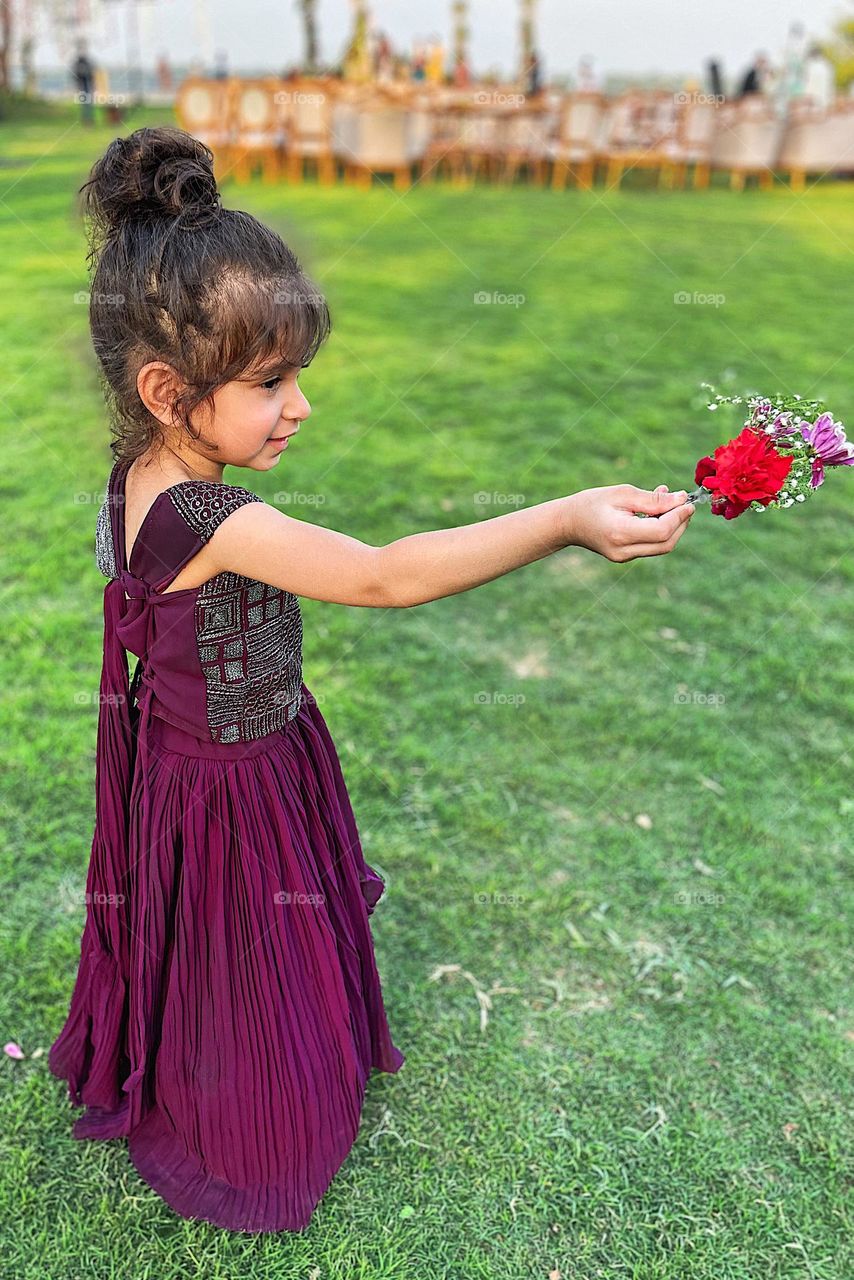 Little girl holding a bouquet of flowers and pointing, toddler girl at wedding, toddler at Indian wedding, flower girl at wedding, cute toddler holds flowers, dressing up like a princess 