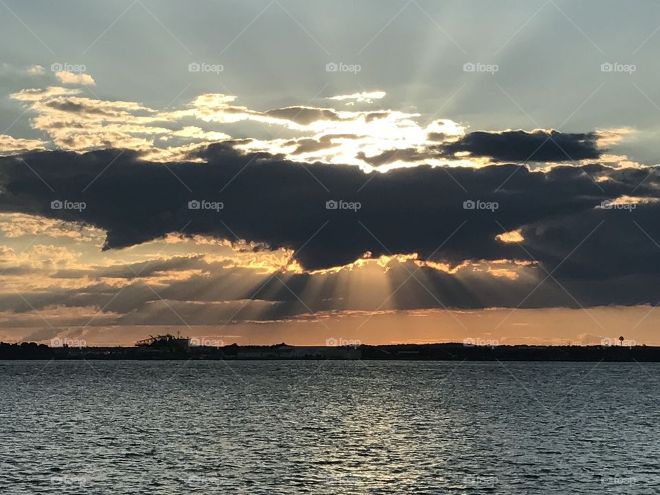 Sunbeams over water at sunset. 