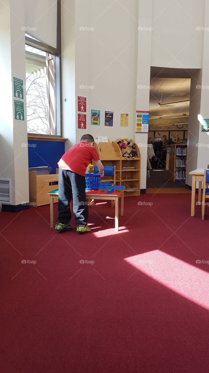 boy playing at table in library