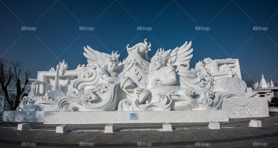 Asia china  Harbin ice Festival snow Festival ice sculptures snow building  snow ice with polar sun blue sky horse's snow building