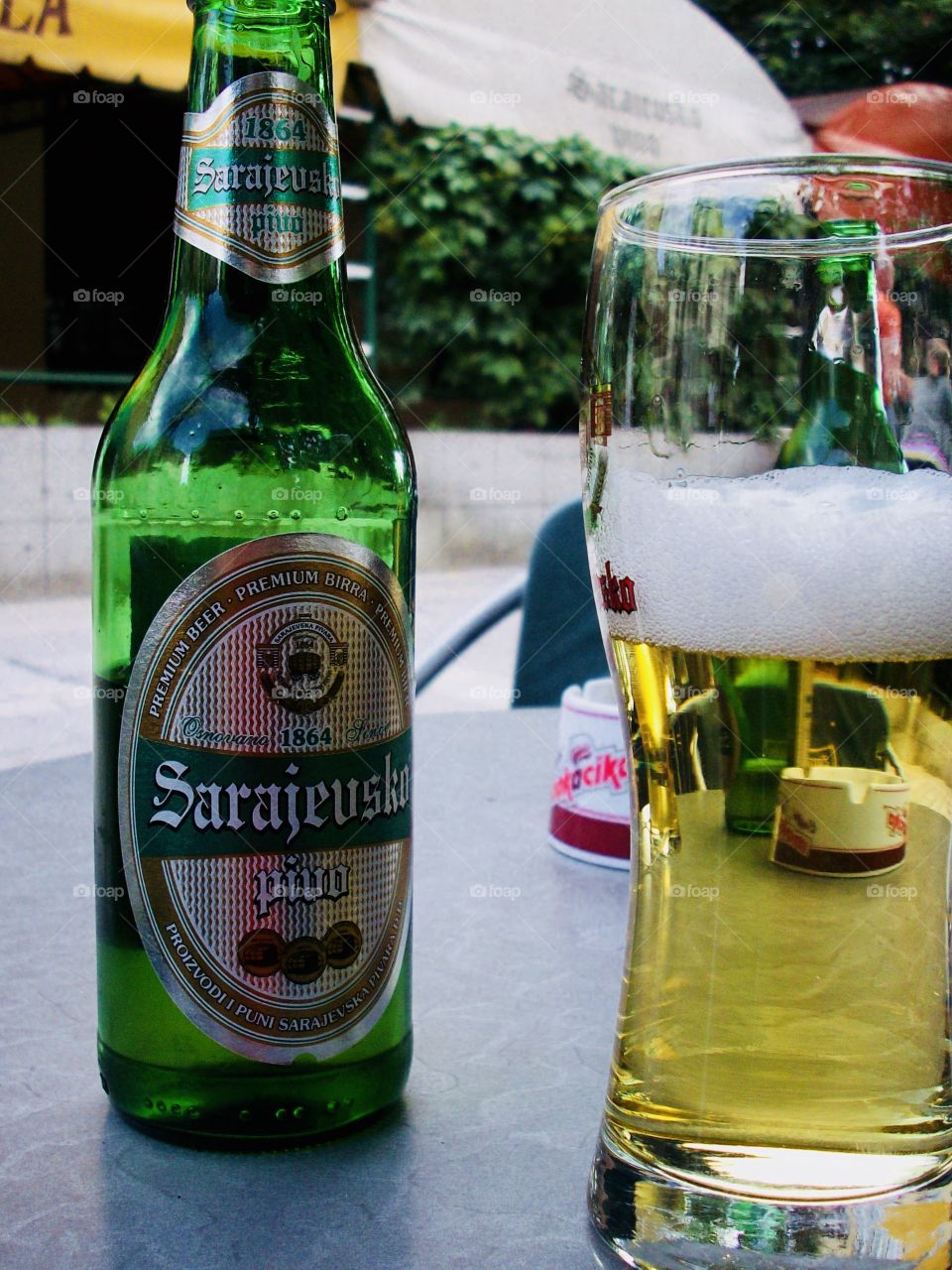 A glass and Bottle of Sarajevsko beer on a Café table