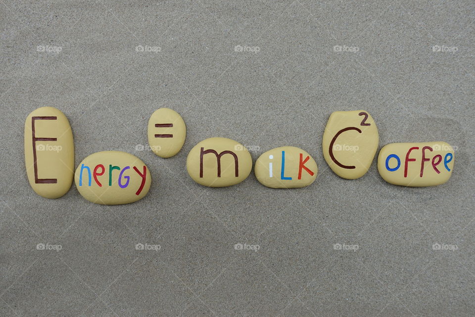 Theory of relativity  or Theory of coffee power with carved and colored stones over beach sand