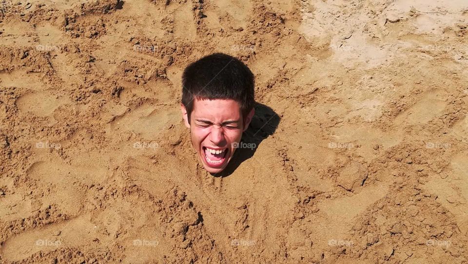scared boy under the sand