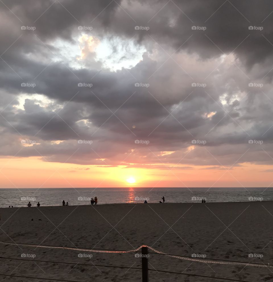 Contrast of colorful Sunset just before the grey storm clouds open up with rain