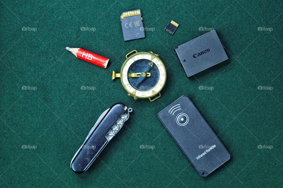 travel items arranged in a circle on a green cloth