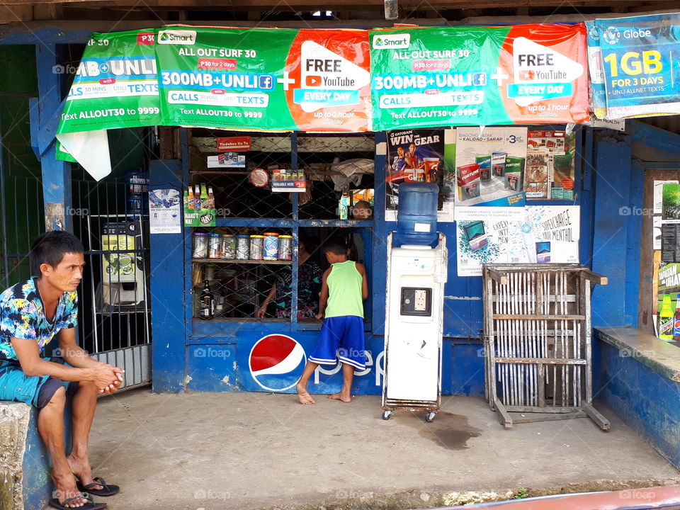 Young child buying something in a sari sari in the Philippines.