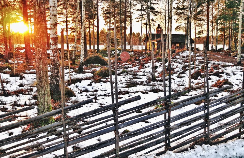 A lake cabin in winter at sunrise