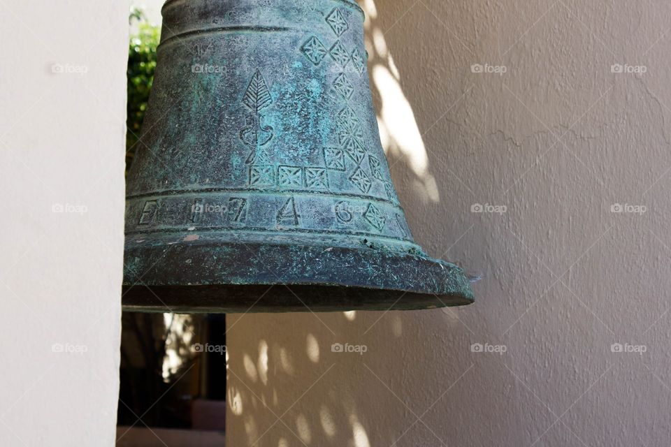 Closeup of old bell with green rust found on the exterior of an old church in Cabo San Lucas, Mexico