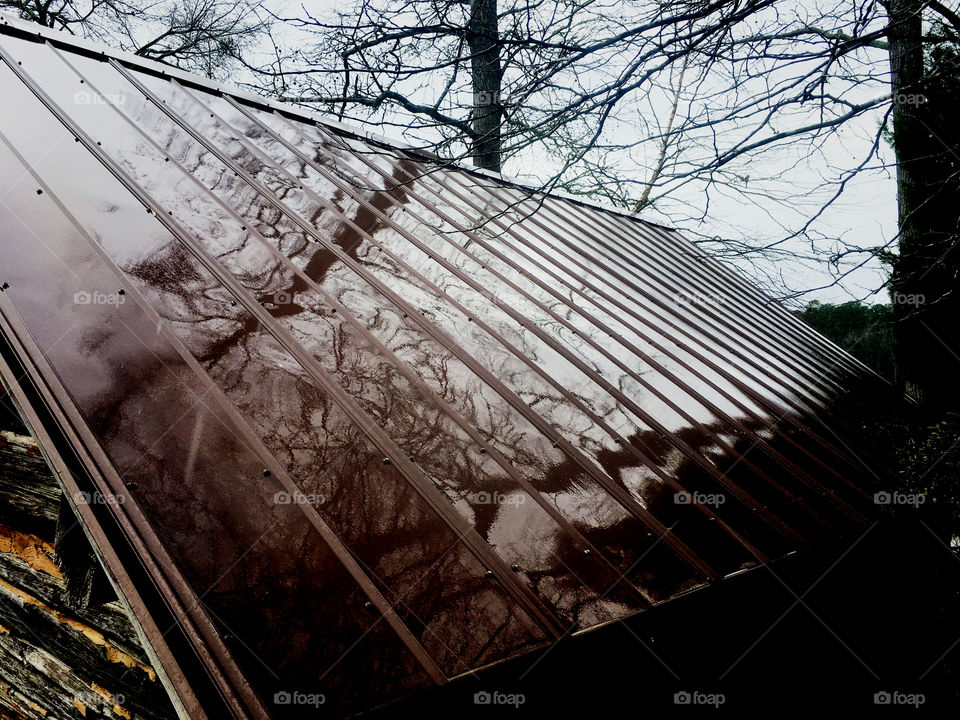 Fresh rain water on a brown tin roof revealing a shiny shimmery finish 