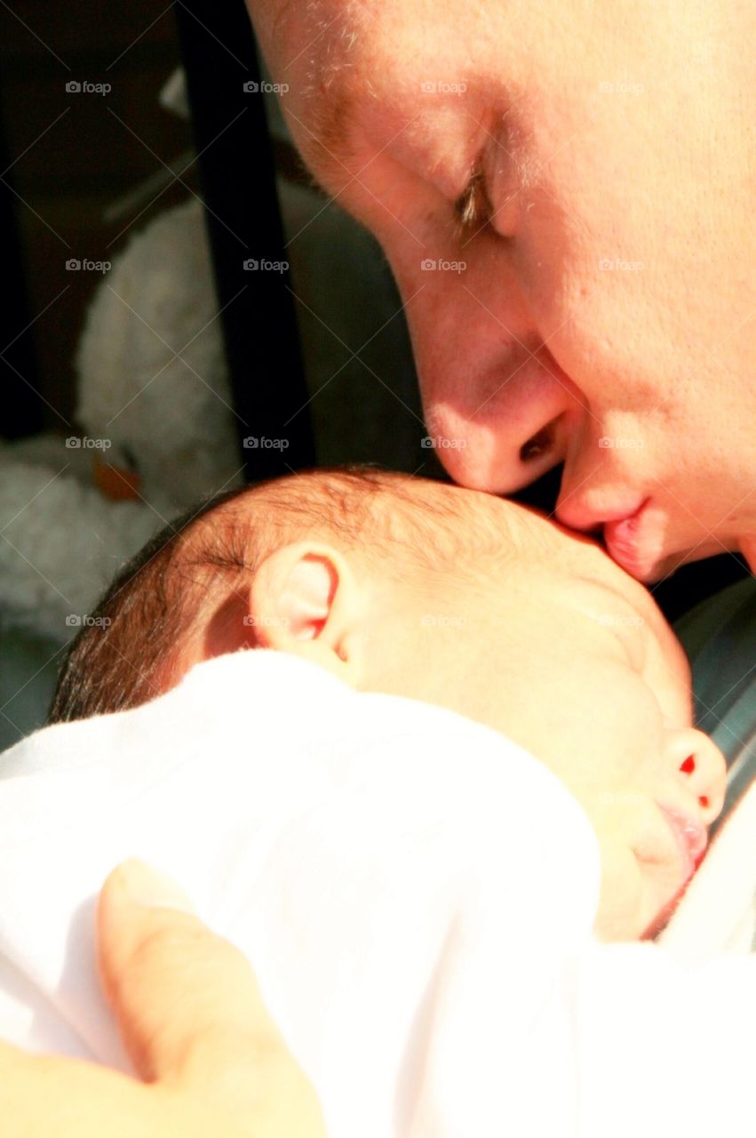 Proud Dad with his Little Girl. Kissing his daughter in THE sunlight
