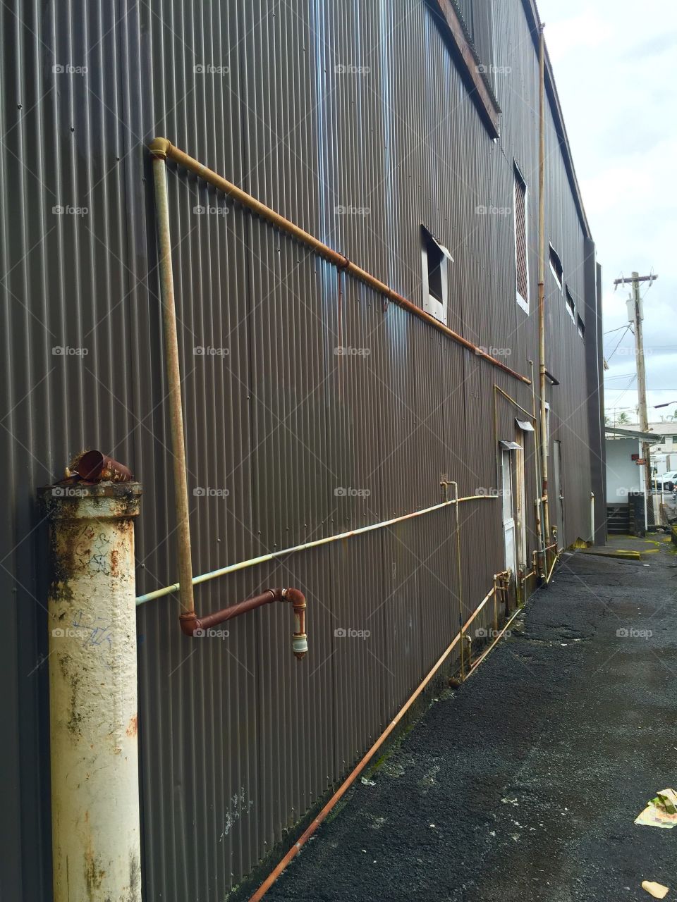 Pipes on a Brown Roof Metal Wall
