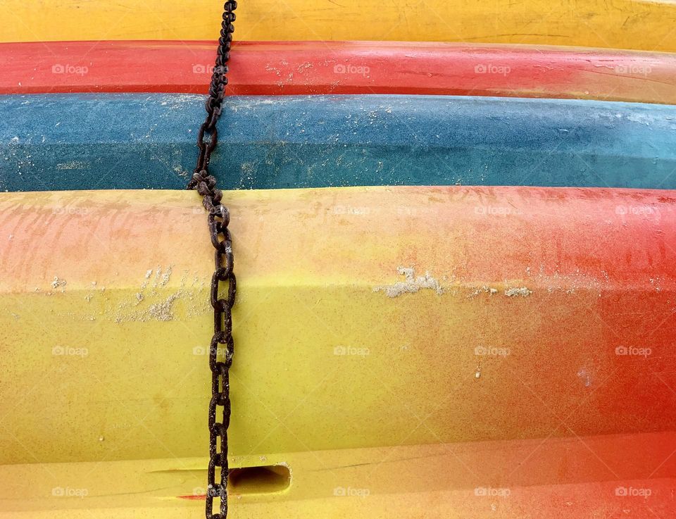 Different colors of chained kayak boat on the shore in a close up photos. Bahamas. 