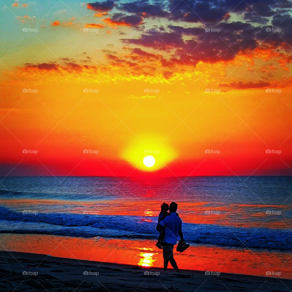 The Golden Hour . Father and son enjoying a walk on the beach at sunrise in Bradley Beach, NJ  