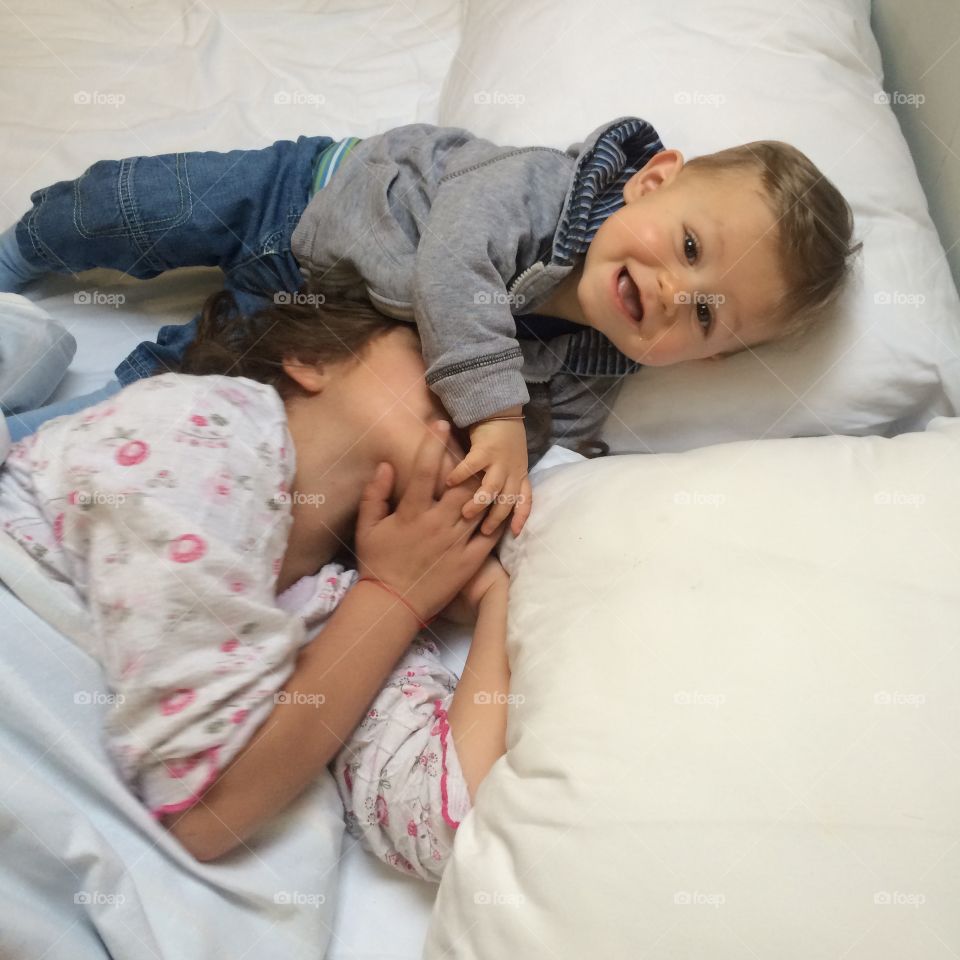 Brother and sister lying bed