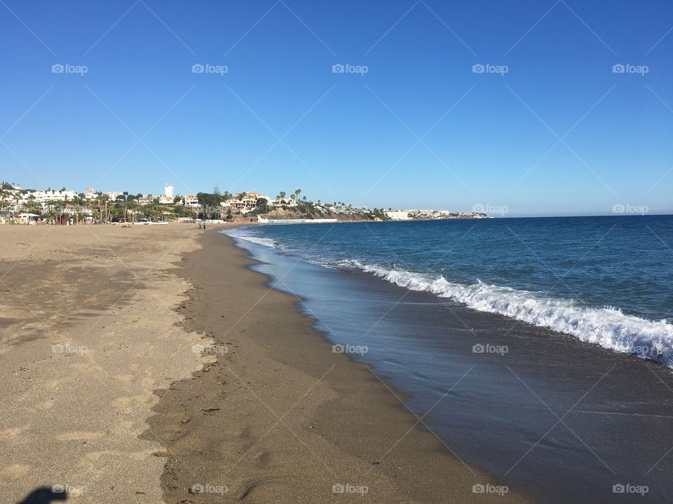 Contrasting colours at the beach. The blue skies of the Costa Del Sol perfectly frames the sea and sand. The picture instantly relaxes you!