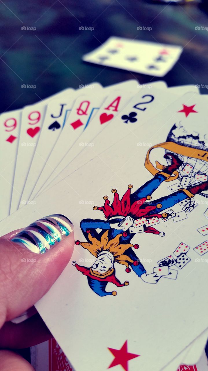 fanned out hand of cards with a top joker