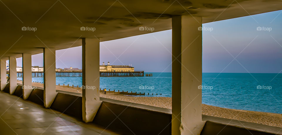 Rectangles of the sea and pier can be seen through the cut out windows of this seafront underpass