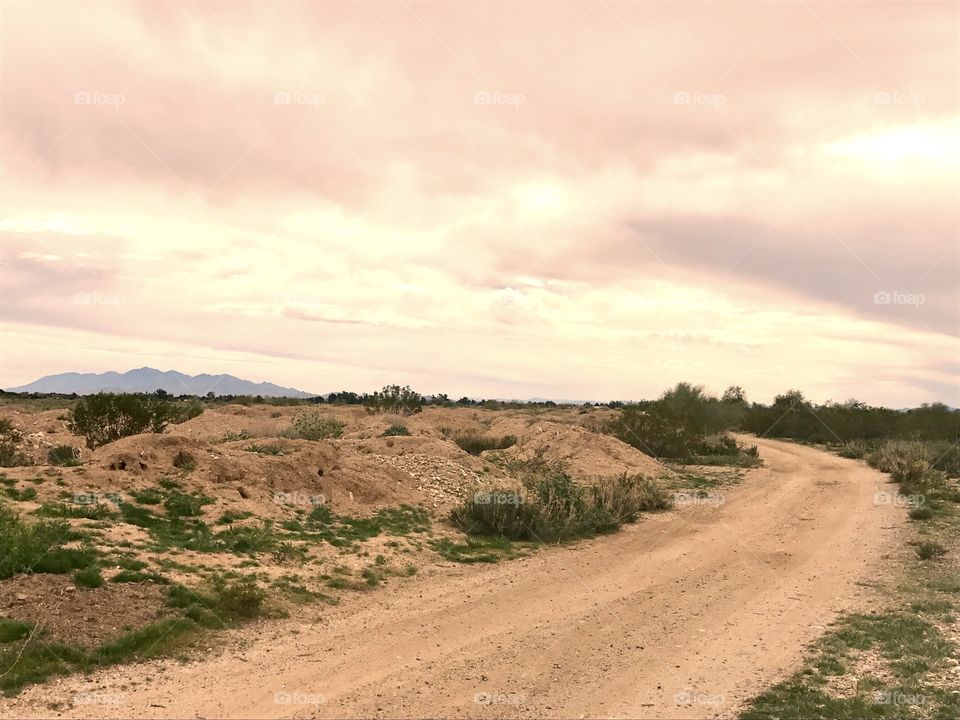 Empty road against cloudy sky