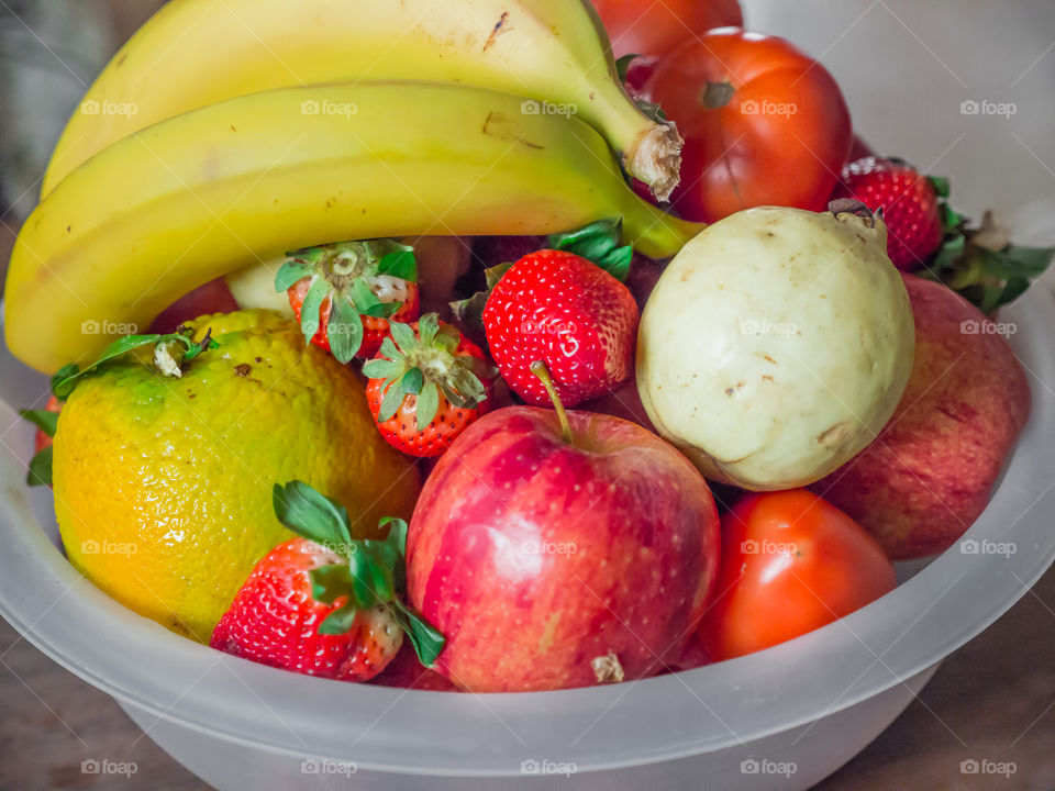 Fruits bowl. Bananas, Apple, guava, tomatoes, strawberries, orange