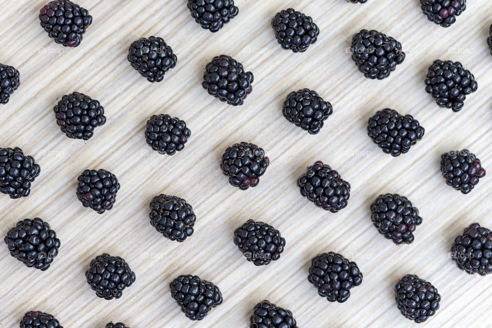 Blackberries on wooden background arranged in diagonal pattern