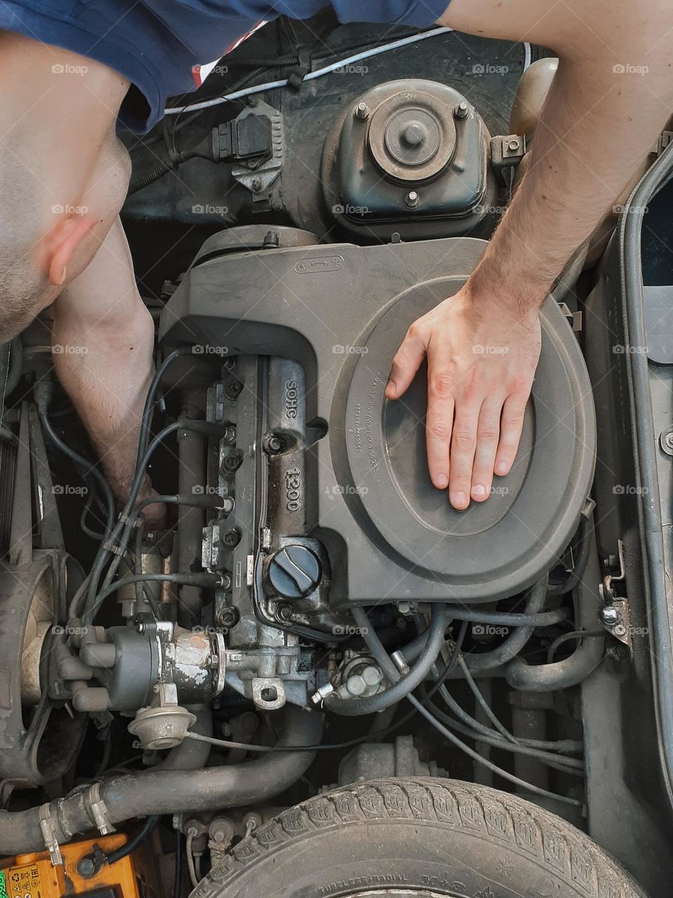 The mechanic conducts diagnostics under the hood of the old Slavuta