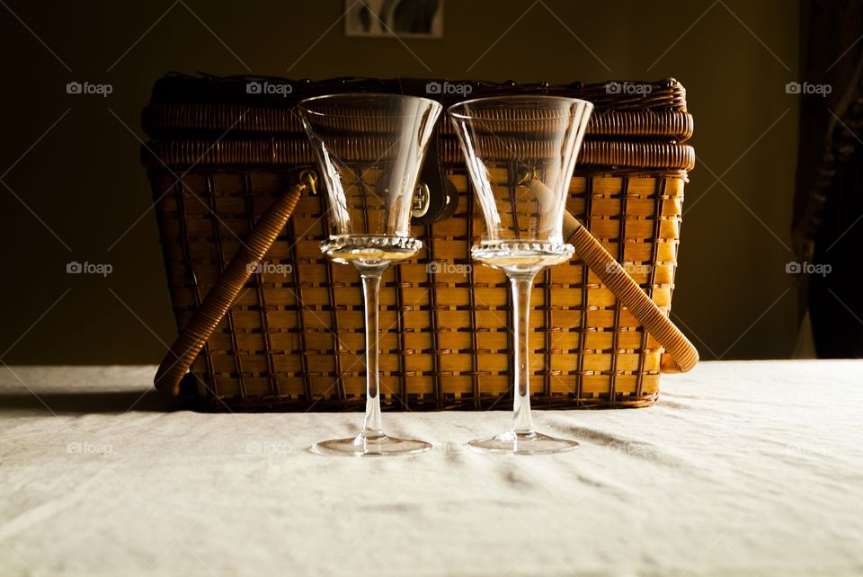 As the Coronavirus pandemic rages across the globe with family's and couples confined to their homes wine glasses and a picnic basket at a kitchen table are a symbol of togetherness and love during a difficult time.