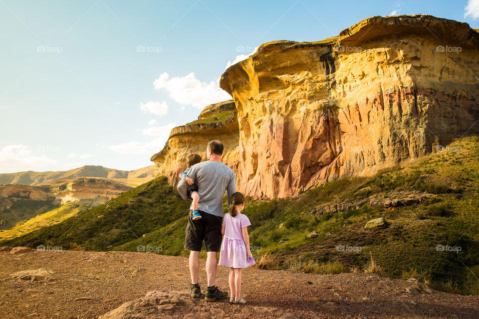 Something I love - my family! Image of man with his children overlooking Sandstone mountain cliffs at sunset. Such a beautiful picture of love and being together.
