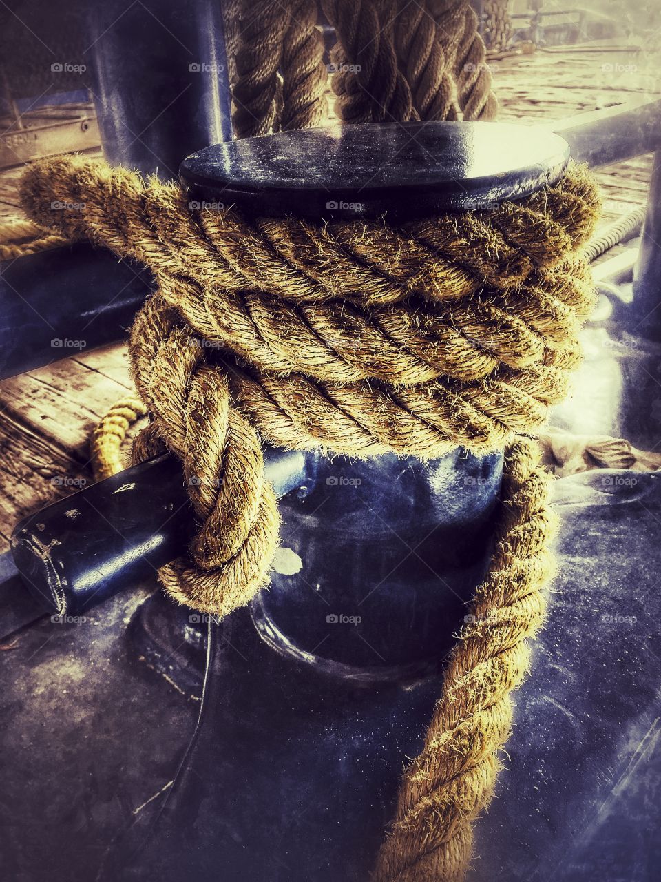 Nylon rope tied around a bit on deck of a crew ship