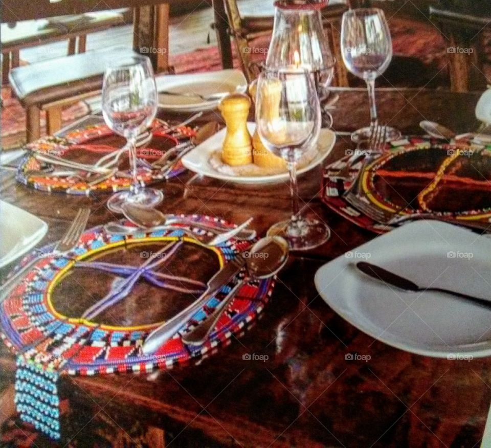 A neatly designed and arranged dinning table with beautifully placed utensils with African hand-made table mats in readiness for a meal.