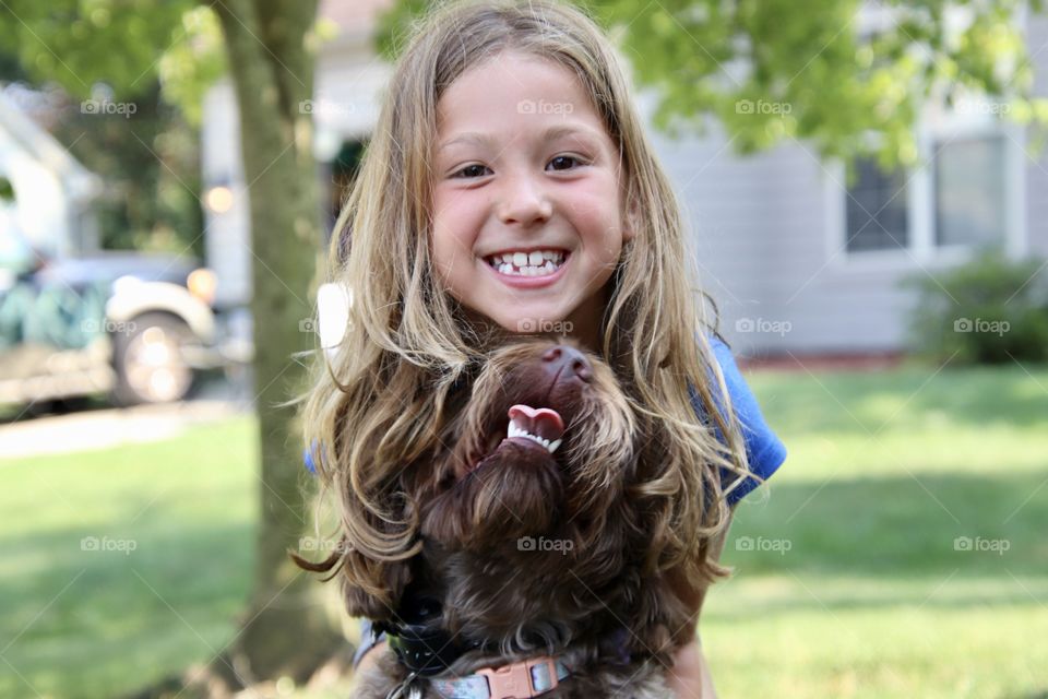 Little girl with her dog and big smiles