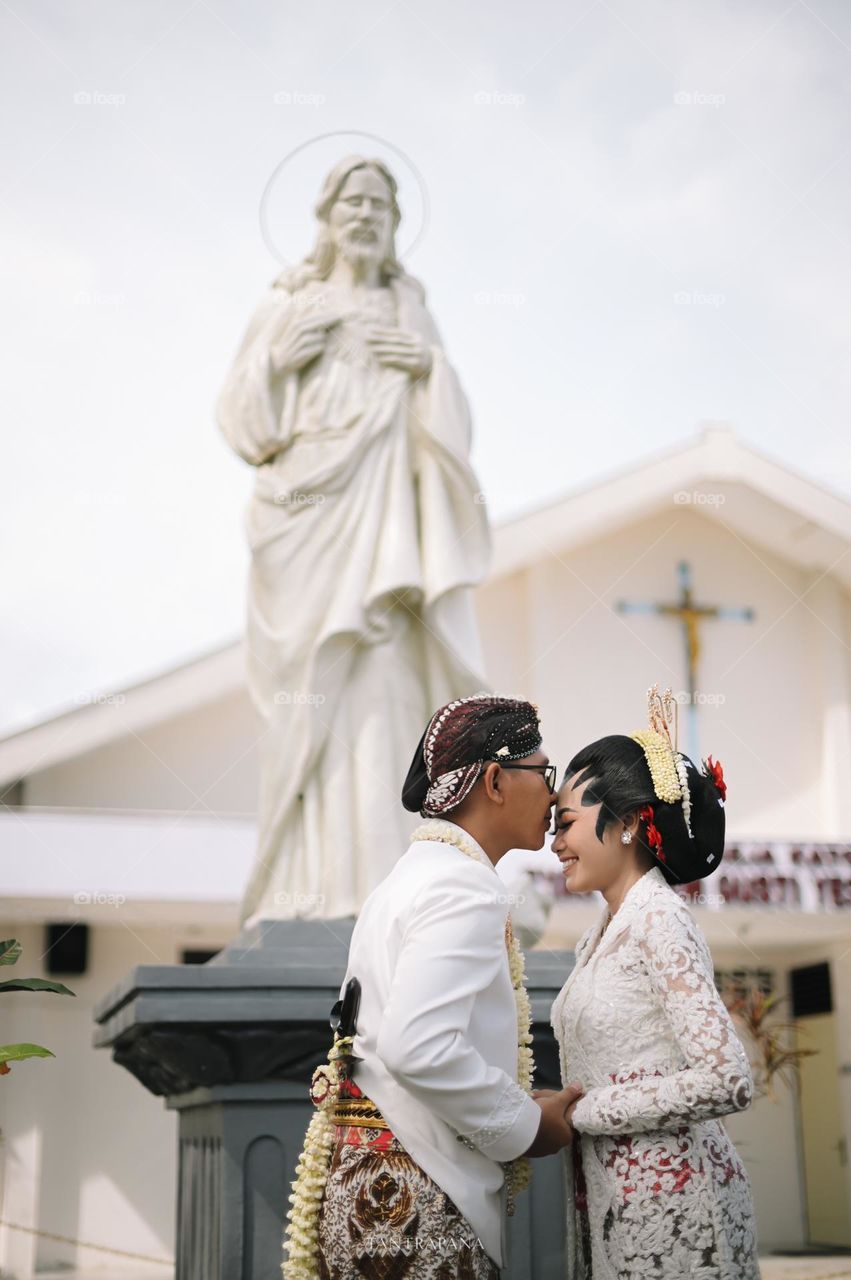 wedding kiss in front of Jesus and Church