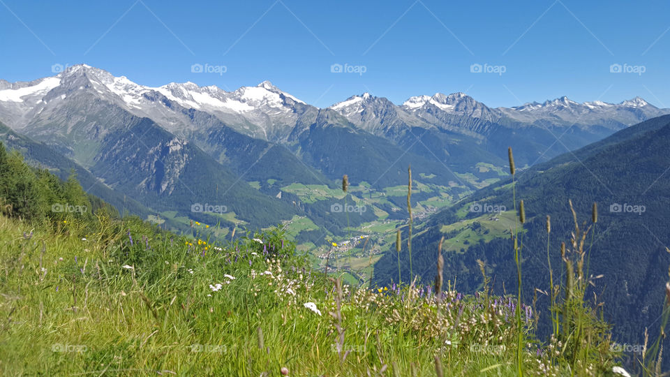 Hiking trail in the mountains, panoramic view of mountain peaks with snow 