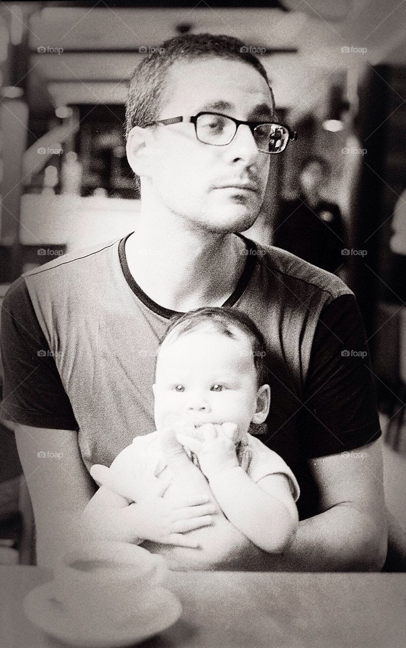 Father drinking coffee with baby