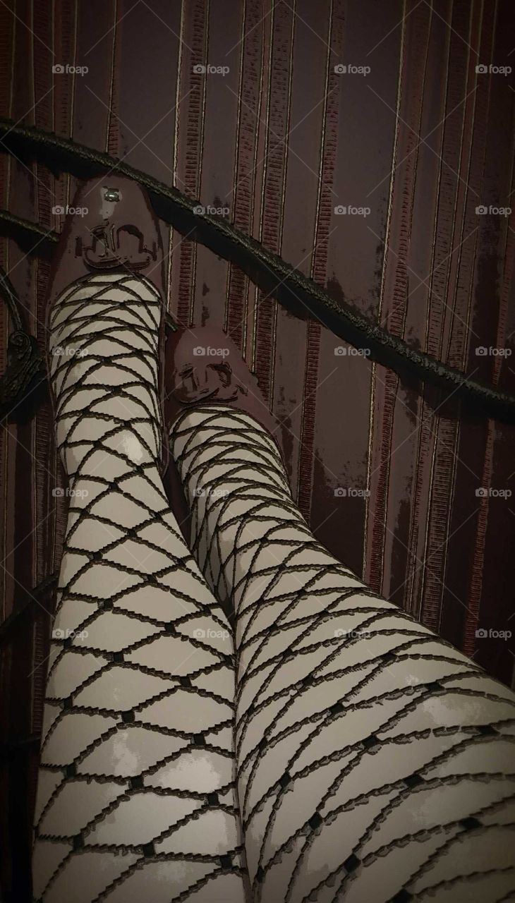 Fishnet stockings and red pumps lend a fun perspective to a boudoir shot.