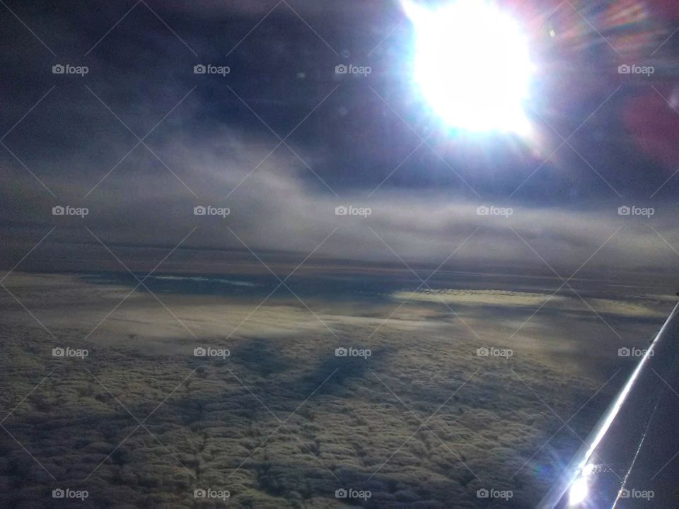 airplane view of clouds that have shadows on them from clouds above