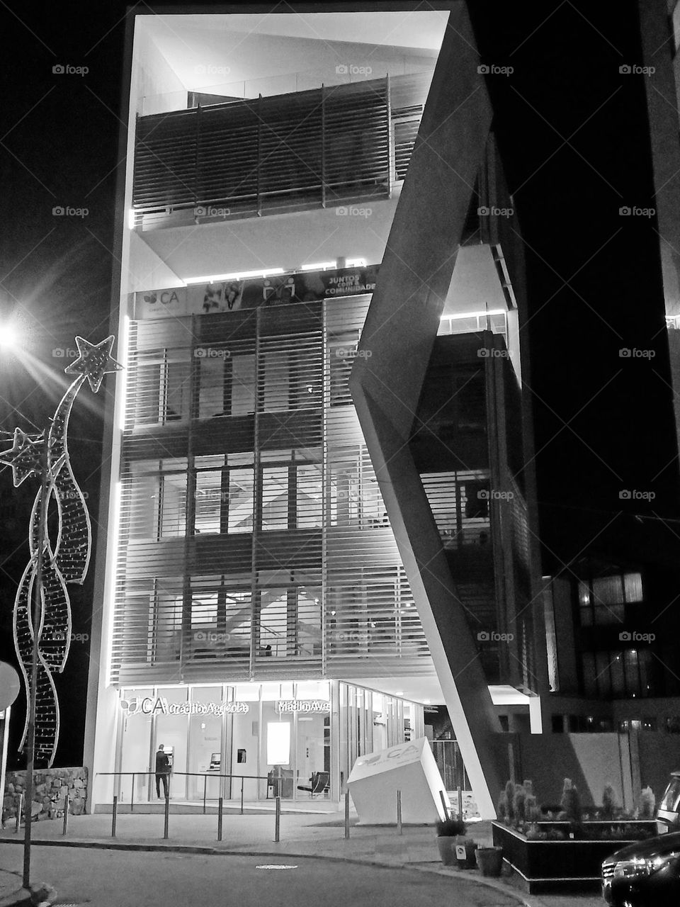 A lonely moment in the silence of the night, under the modern lights of a geometric building.