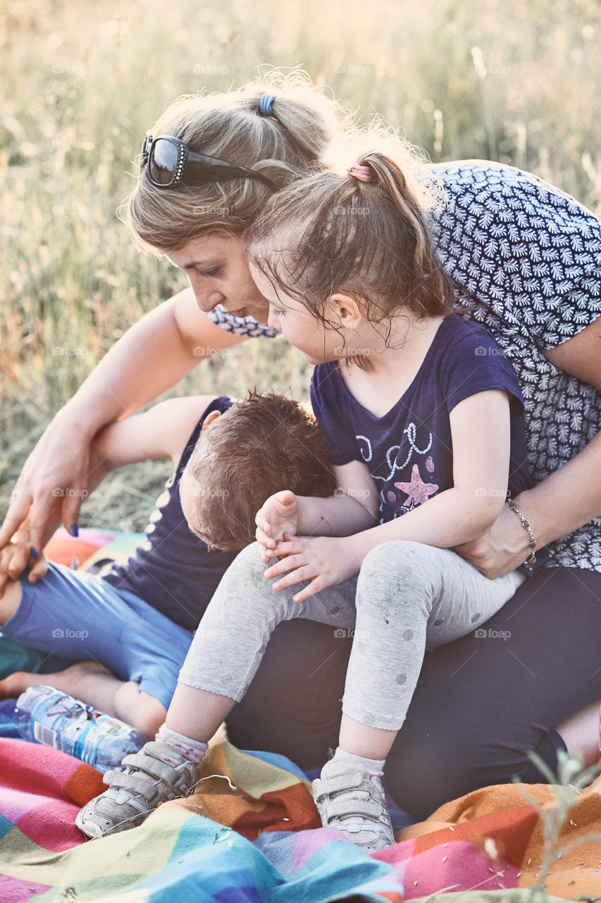 Family spending time together on a meadow, close to nature. Parents and children playing together. Candid people, real moments, authentic situations